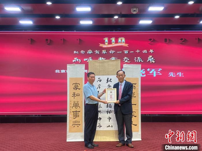 开幕式上，黄典本(右)向台湾会馆捐赠台湾书画家作品，北京市台联秘书长张晓军(左)接受捐赠。　刘大炜 摄